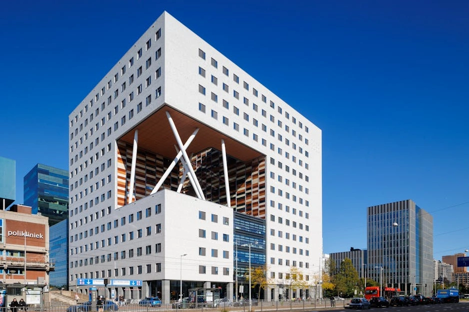 Moderní business centrum s prosklenou fasádou odrážející oblohu.